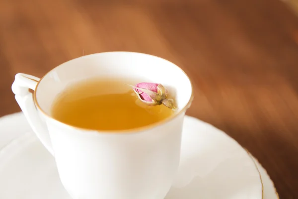 Vintage Tasse Tee mit Rosenblüten, auf braunem Hintergrund — Stockfoto