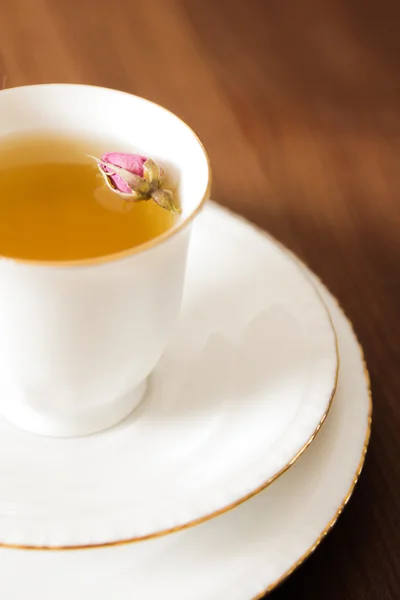 Vintage Tasse Tee mit Rosenblüten, auf braunem Hintergrund — Stockfoto