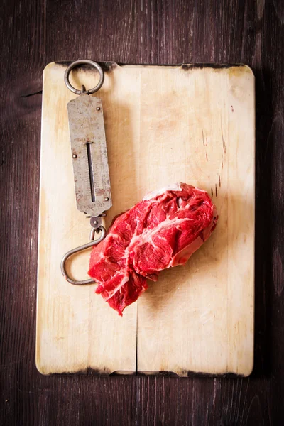 Шматок сирого м'яса з ручними вагами старий — стокове фото
