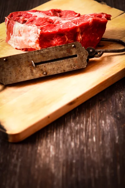 Sepotong daging mentah dengan berat tangan tua — Stok Foto