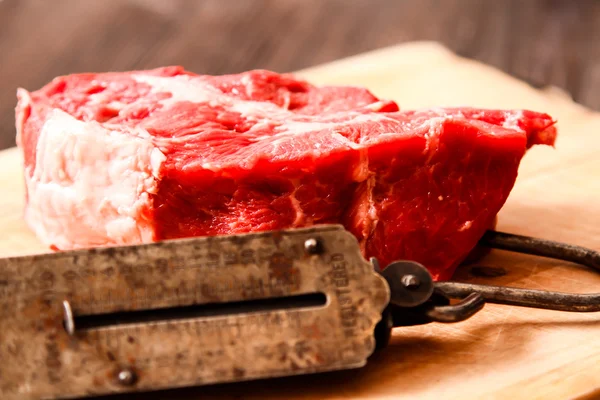 Sepotong daging mentah dengan berat tangan tua — Stok Foto