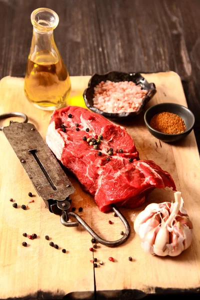 Pedaço de carne crua com pesos de mão velho — Fotografia de Stock