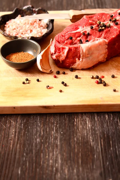 Piece of raw meat with garlic and herbs — Stock Photo, Image