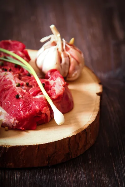 Pezzo di carne cruda con erbe aromatiche e olio d'oliva — Foto Stock