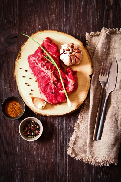 Pedaço de carne crua com ervas e azeite — Fotografia de Stock