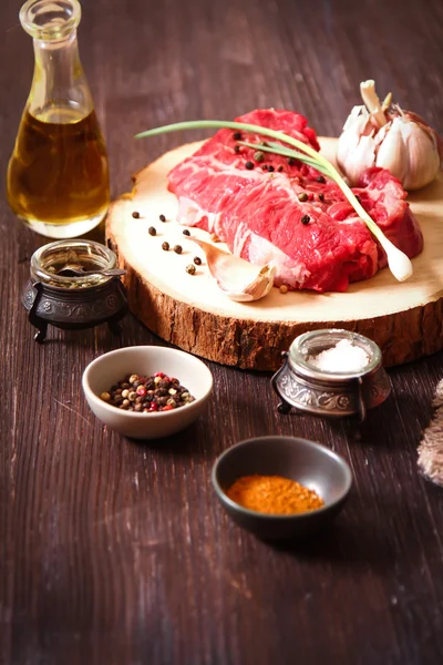 Pedaço de carne crua com ervas e azeite — Fotografia de Stock
