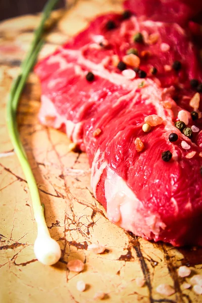 Pedaço de carne crua com ervas e azeite — Fotografia de Stock