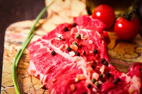 Pedaço de carne crua com ervas e azeite — Fotografia de Stock