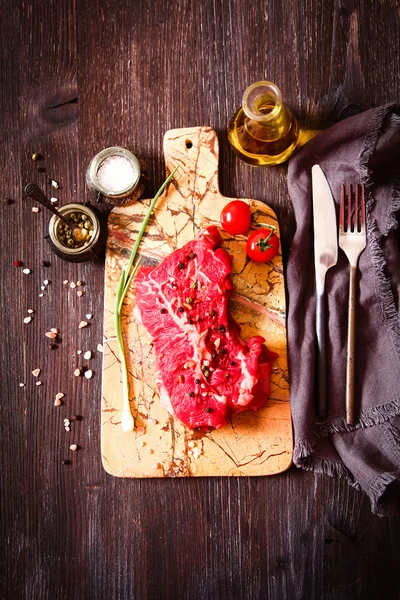 Кусок сырого мяса с травами и оливковым маслом — стоковое фото
