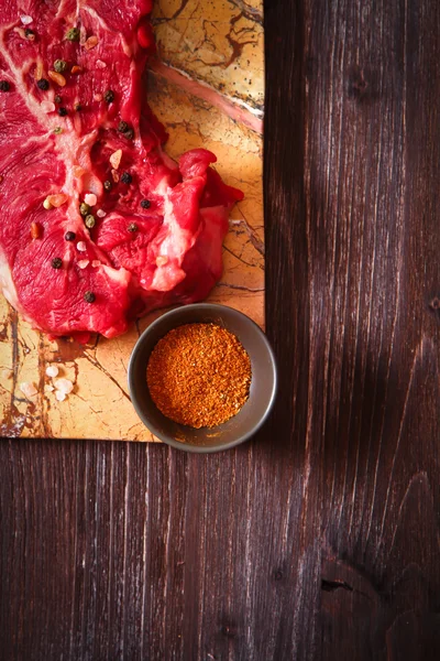 Pedaço de carne crua com ervas e azeite — Fotografia de Stock