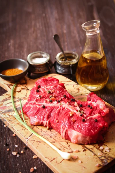 Pedaço de carne crua com ervas e azeite — Fotografia de Stock