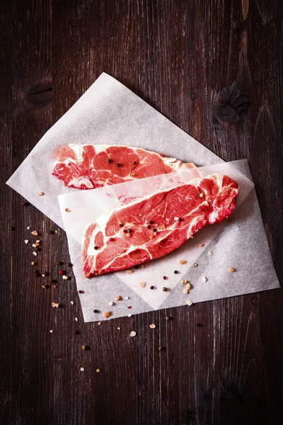 Kus syrového masa na bílém papíře s pepřem — Stock fotografie