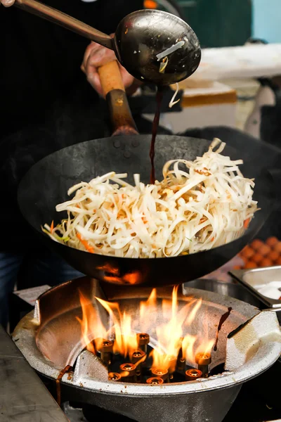 Street food. fried noodles in a wok with chicken and prawns — Stock Photo, Image