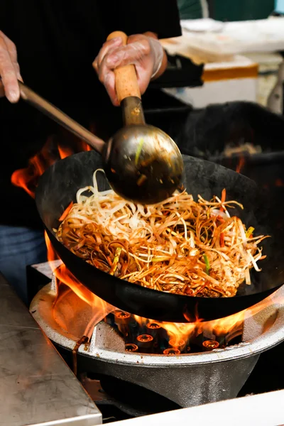 Street food. fried noodles in a wok with chicken and prawns — Stock Photo, Image