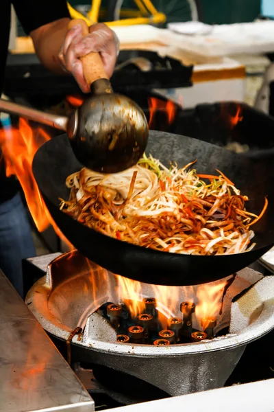 Street food. fried noodles in a wok with chicken and prawns — Stock Photo, Image