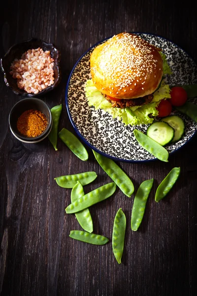 Homemade veggie burger in a bun with sesame seeds of beer. — Stock Photo, Image