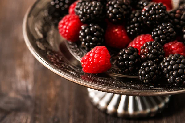 Raspberries and blueberries on a plate in the Oriental style — Stock Photo, Image