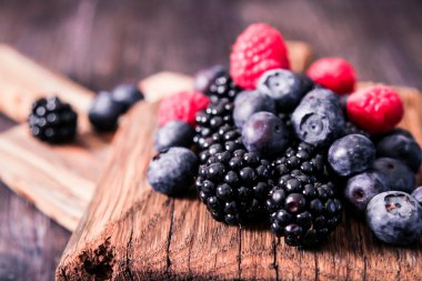 yaban mersini ve ahududu ahşap arka plan üzerinde