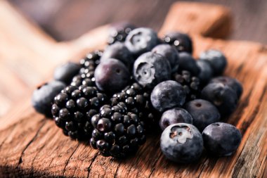 yaban mersini ve ahududu ahşap arka plan üzerinde