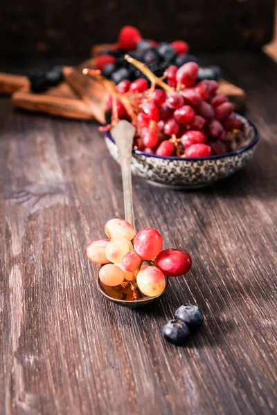 Jagody i czerwone winogrona na tle drewniane — Zdjęcie stockowe
