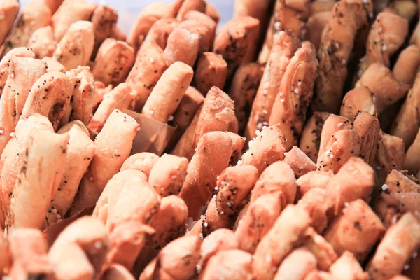 Palitos de pan crujientes con sal y romero fresco a bordo oscuro . — Foto de Stock