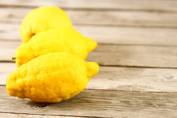 Свежие лимоны на деревянном столе — стоковое фото