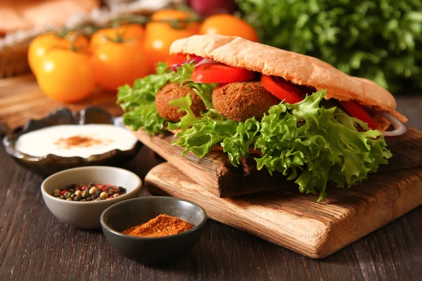 Dönerspieß - Falafel mit frischem Gemüse in Fladenbrot auf hölzernen Ta — Stockfoto