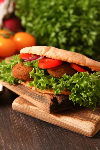 Dönerspieß - Falafel mit frischem Gemüse in Fladenbrot auf hölzernen Ta — Stockfoto