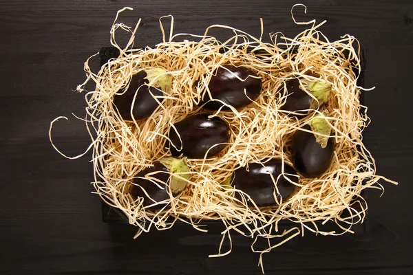 Aubergines fraîches de différentes couleurs sur fond bois foncé. Ve — Photo