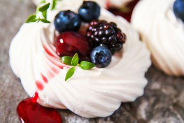 Beze tatlısı Pavlova kek gri bir taş üzerinde taze çilek ile