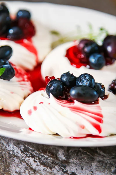 Meringue dessert Pavlova cake with fresh berries on a gray stone — Stock Photo, Image