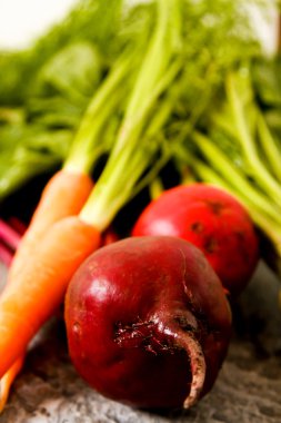 Eski bir ahşap masa üzerinde yeşil yaprakları ile organik kırmızı pancar. Pas