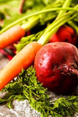 Eski bir ahşap masa üzerinde yeşil yaprakları ile organik kırmızı pancar. Pas