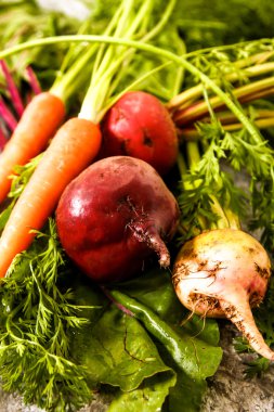 Eski bir ahşap masa üzerinde yeşil yaprakları ile organik kırmızı pancar. Pas