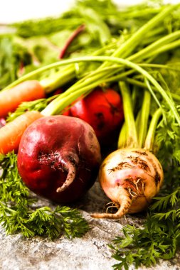 Eski bir ahşap masa üzerinde yeşil yaprakları ile organik kırmızı pancar. Pas