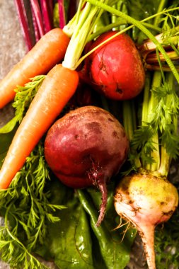 Eski bir ahşap masa üzerinde yeşil yaprakları ile organik kırmızı pancar. Pas