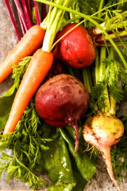 Eski bir ahşap masa üzerinde yeşil yaprakları ile organik kırmızı pancar. Pas