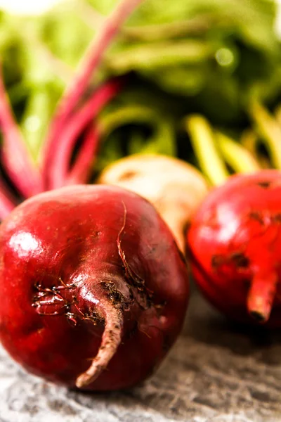 Biologische rode bieten met groene bladeren op een oude houten tafel. Roest — Stockfoto