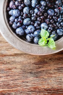 Mavi olgun yaban mersini bir metal plaka. ahşap arka plan. Sayfanın Üstü 
