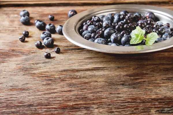 Blue ripe blueberries in a metal plate.  wooden background. — Stock Photo, Image