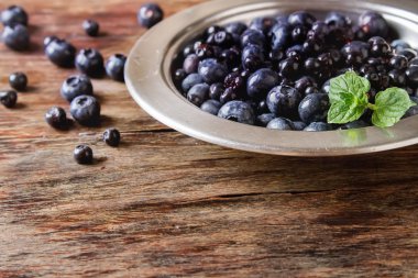 Mavi olgun yaban mersini bir metal plaka. ahşap arka plan.