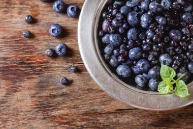 Mavi olgun yaban mersini bir metal plaka. ahşap arka plan. Sayfanın Üstü 