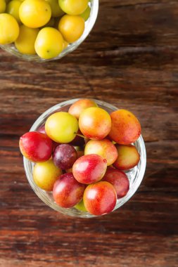 Olgun Erik bir cam. Koyu ahşap arka plan