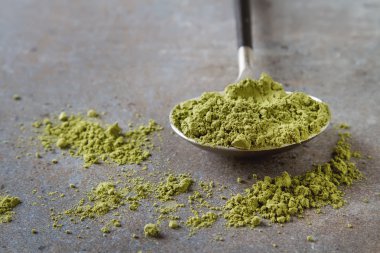 Matcha çay siyah saplı bir kaşık. Gri arka planı.