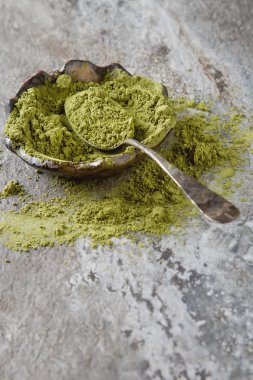 Matcha çay bir küçük kahverengi plaka kuru. Koyu seramik arka plan