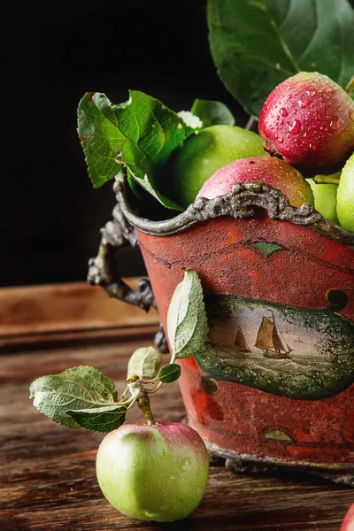 Витерти органічні яблука у червоній старовинній вазі. фон з темного дерева — стокове фото