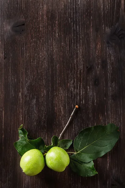 Manzana verde madura con hojas. Fondo de madera oscura. vista superior —  Fotos de Stock