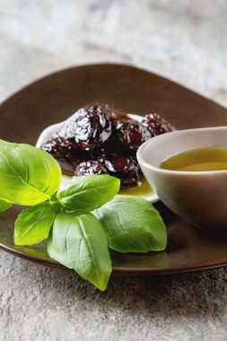 Yeşil Konfit zeytin ve zeytin yağı bir kapta. Koyu arka plan.