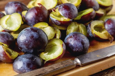 Olgun Erik kahverengi ahşap zemin üzerinde dağınık. Biyo sağlıklı f