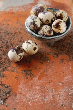 Eski gri plaka üzerinde küçük bıldırcın yumurtası. Kırmızı taş zemin